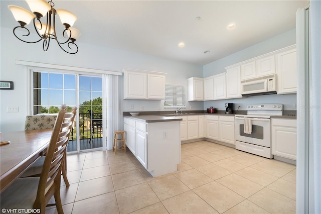 20130 Sunset Landing Ave, Groveland, FL 34736 - kitchen with white appliances, a chandelier, plenty of natural light, white cabinetry, and recessed lighting