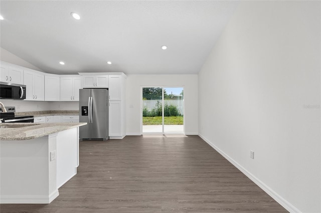 654 NE 130th Ct, Silver Springs, FL 34488 - kitchen featuring appliances with stainless steel finishes, lofted ceiling, white cabinets, light stone countertops, and dark wood-type flooring
