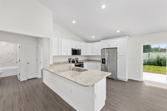 654 NE 130th Ct, Silver Springs, FL 34488 - kitchen with stainless steel appliances, vaulted ceiling, dark wood-style flooring, a peninsula, and white cabinetry
