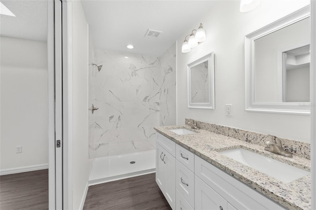 654 NE 130th Ct, Silver Springs, FL 34488 - full bathroom featuring double vanity, a marble finish shower, wood finished floors, and recessed lighting