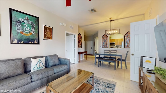 7675 Comrow St Unit 404, Kissimmee, FL 34747 - living area featuring arched walkways, light tile patterned flooring, a ceiling fan, and a chandelier