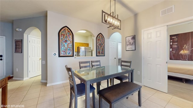 7675 Comrow St Unit 404, Kissimmee, FL 34747 - dining room featuring arched walkways, light tile patterned floors, and a chandelier