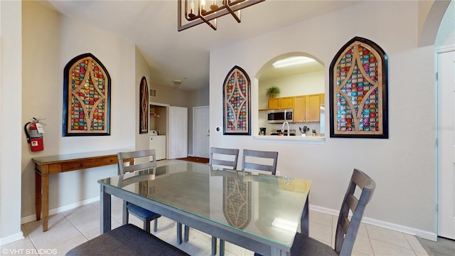 7675 Comrow St Unit 404, Kissimmee, FL 34747 - dining room featuring light tile patterned floors, a chandelier, and arched walkways