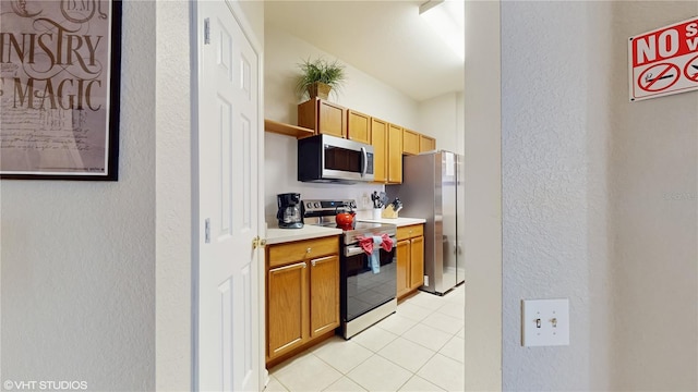 7675 Comrow St Unit 404, Kissimmee, FL 34747 - kitchen featuring stainless steel appliances, a textured wall, light countertops, light tile patterned floors, and open shelves