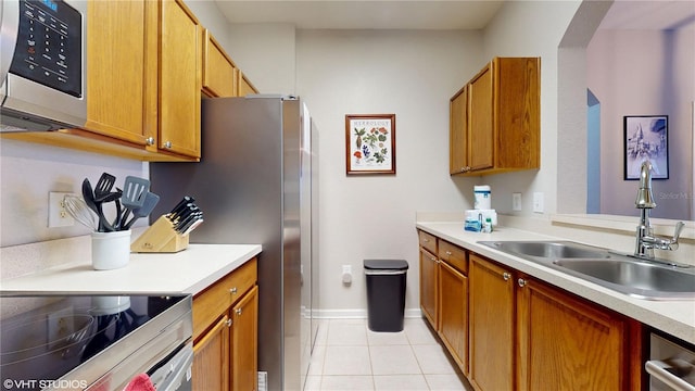 7675 Comrow St Unit 404, Kissimmee, FL 34747 - kitchen with appliances with stainless steel finishes, light tile patterned floors, light countertops, and brown cabinets
