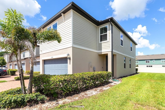 1024 Desert Candle Dr, Ocoee, FL 34761 - view of property exterior with a garage, a yard, and stucco siding