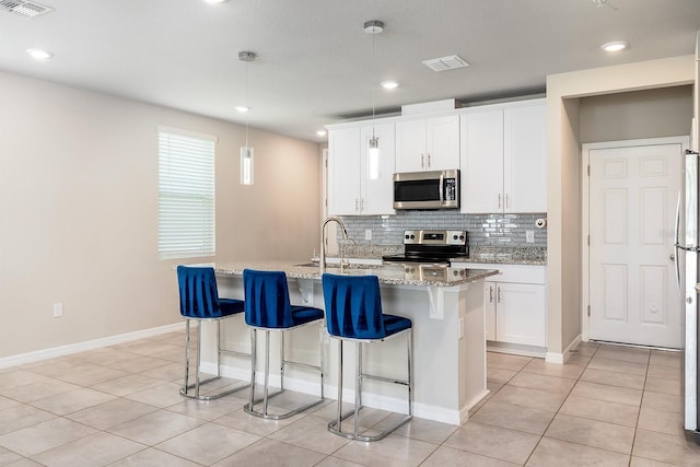 1024 Desert Candle Dr, Ocoee, FL 34761 - kitchen featuring stainless steel appliances, decorative backsplash, light tile patterned flooring, a breakfast bar, and light stone counters