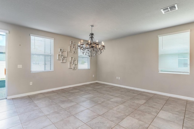 1024 Desert Candle Dr, Ocoee, FL 34761 - spare room with a chandelier, light tile patterned floors, and a textured ceiling
