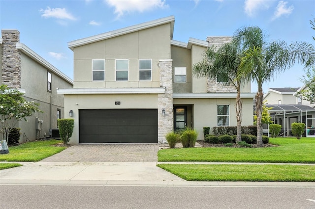 369 Ocean Course Ave, Davenport, FL 33896 - view of front facade featuring stucco siding, decorative driveway, stone siding, an attached garage, and a front yard