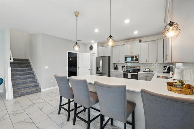 369 Ocean Course Ave, Davenport, FL 33896 - kitchen with appliances with stainless steel finishes, light countertops, light marble finish floors, a peninsula, and a kitchen bar