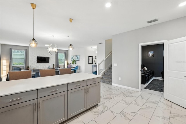 369 Ocean Course Ave, Davenport, FL 33896 - kitchen with gray cabinets, plenty of natural light, light marble finish flooring, light countertops, and recessed lighting