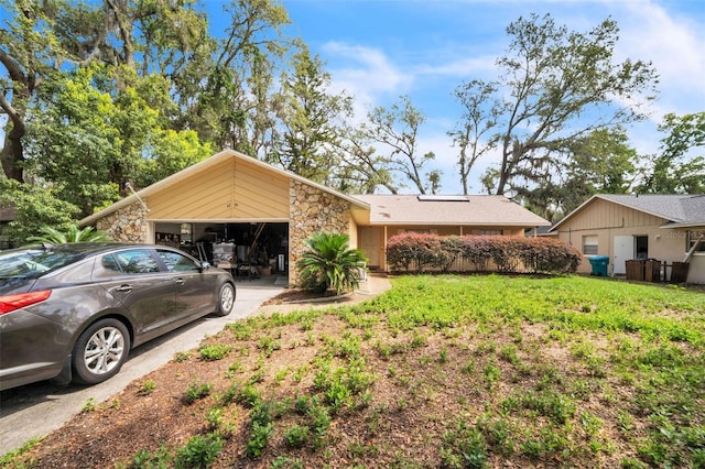 4799 Lighthouse Rd, Orlando, FL 32808 - view of front of home with an attached garage, concrete driveway, stone siding, and a front lawn