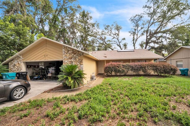4799 Lighthouse Rd, Orlando, FL 32808 - view of front of house with stone siding, concrete driveway, and a garage