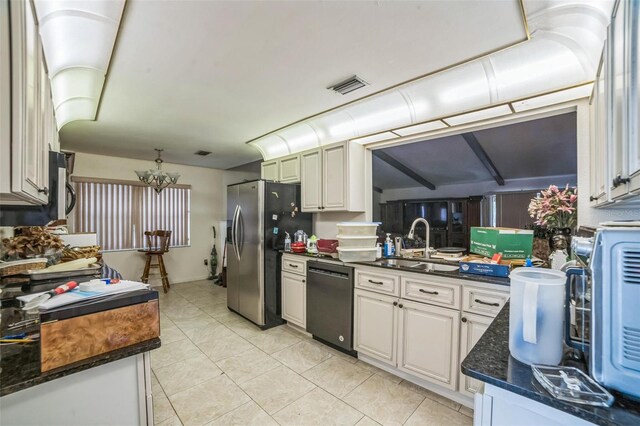 4799 Lighthouse Rd, Orlando, FL 32808 - kitchen with dishwasher, stainless steel fridge, a chandelier, light tile patterned floors, and dark stone counters