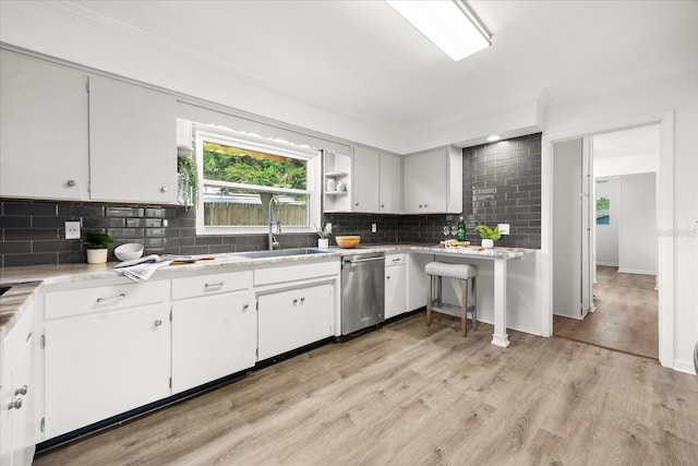1505 N Lake Mirror Dr NW, Winter Haven, FL 33881 - kitchen featuring dishwasher, backsplash, light wood-style floors, light countertops, and white cabinets