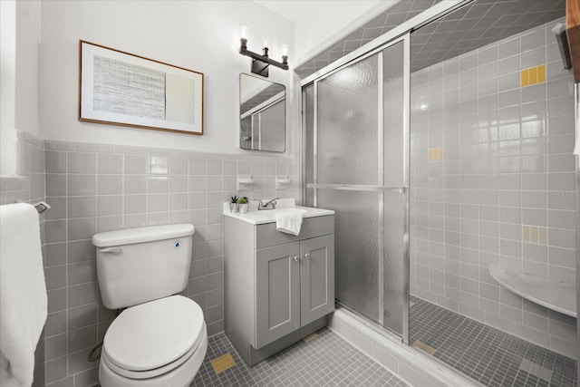 1505 N Lake Mirror Dr NW, Winter Haven, FL 33881 - bathroom featuring vanity, tile patterned floors, a shower stall, a wainscoted wall, and tile walls