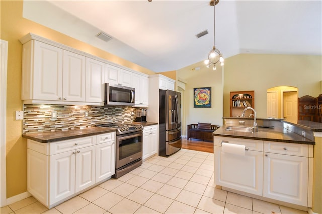 5769 E Price Blvd, North Port, FL 34288 - kitchen with stainless steel appliances, dark countertops, lofted ceiling, light tile patterned flooring, and tasteful backsplash