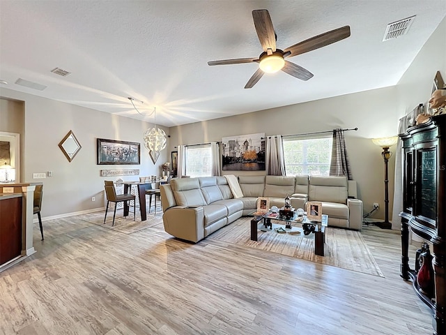 725 Ashworth Overlook Dr Unit C, Apopka, FL 32712 - living room with a ceiling fan, light wood finished floors, a chandelier, and a textured ceiling