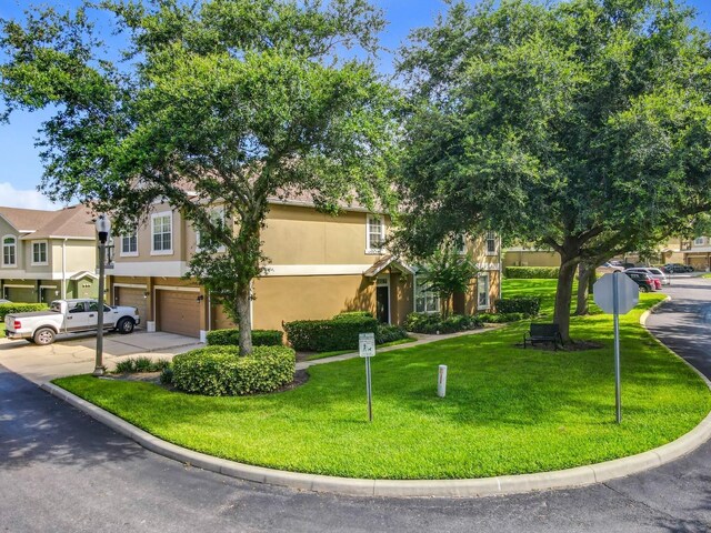 725 Ashworth Overlook Dr Unit C, Apopka, FL 32712 - view of front facade featuring a garage, stucco siding, a front lawn, and driveway
