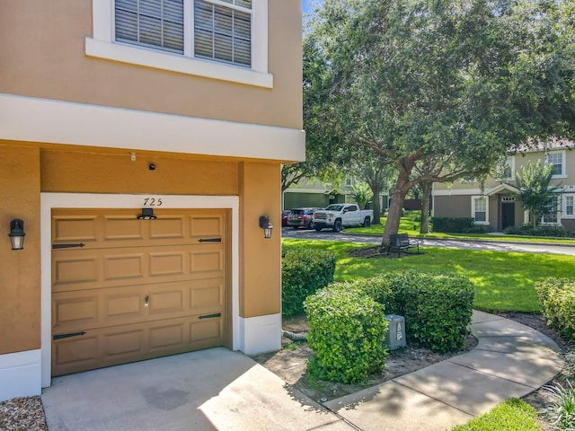 725 Ashworth Overlook Dr Unit C, Apopka, FL 32712 - doorway to property with an attached garage, stucco siding, driveway, and a yard