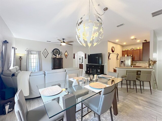 725 Ashworth Overlook Dr Unit C, Apopka, FL 32712 - dining room featuring arched walkways, ceiling fan, light wood-type flooring, and a chandelier