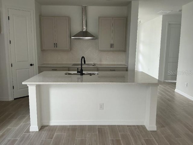 2971 Embark Trl, Saint Cloud, FL 34771 - kitchen with light wood-style floors, gray cabinets, light countertops, a center island with sink, and backsplash
