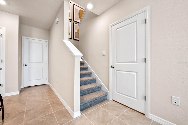 5645 Brosnan Rd, Saint Cloud, FL 34771 - stairs featuring tile patterned floors and a textured ceiling