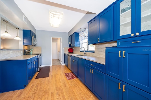 1301 Fahnstock St, Eustis, FL 32726 - kitchen with stainless steel appliances, blue cabinets, light wood-type flooring, and backsplash
