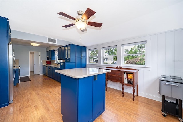 1301 Fahnstock St, Eustis, FL 32726 - kitchen with blue cabinetry, light wood-type flooring, and light countertops