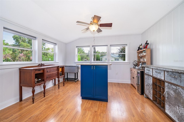 1301 Fahnstock St, Eustis, FL 32726 - kitchen with blue cabinetry, light wood finished floors, vaulted ceiling, ceiling fan, and light countertops