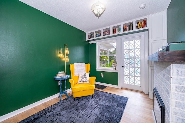 1301 Fahnstock St, Eustis, FL 32726 - living area with wood finished floors, a textured ceiling, and a fireplace