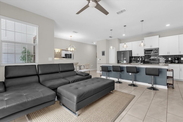 4802 Lullaby Ln, Kissimmee, FL 34746 - living room with a ceiling fan, recessed lighting, light tile patterned floors, and a chandelier