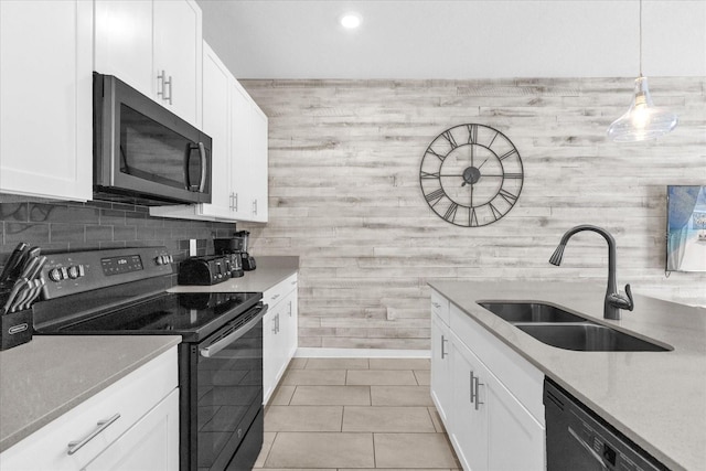 4802 Lullaby Ln, Kissimmee, FL 34746 - kitchen featuring stainless steel microwave, black electric range, dishwasher, white cabinets, and light tile patterned flooring