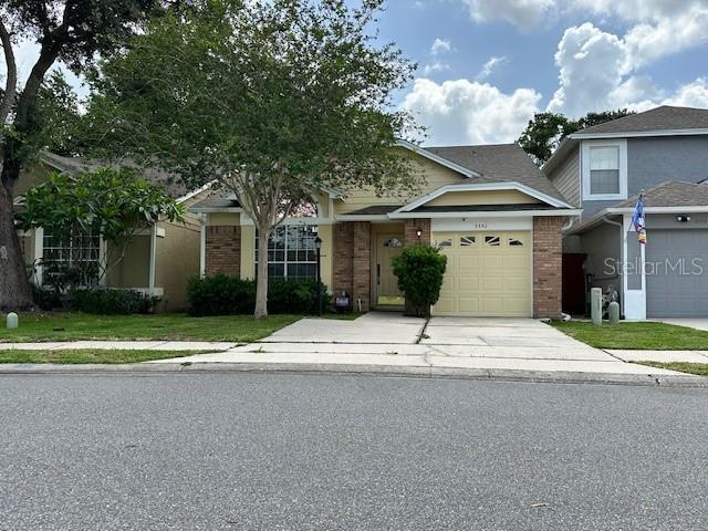 3352 Hamlet Loop, Winter Park, FL 32792 - view of front facade featuring brick siding, driveway, and a garage