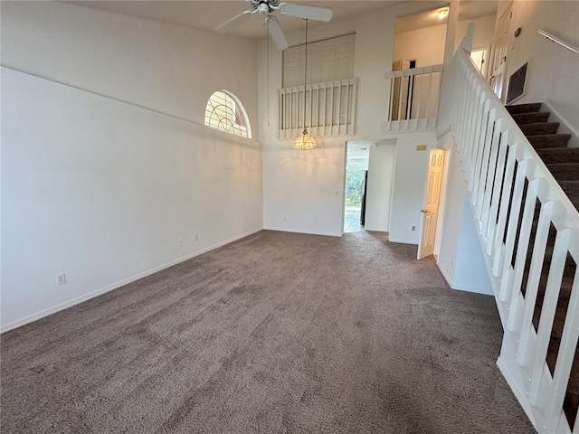 3352 Hamlet Loop, Winter Park, FL 32792 - unfurnished living room featuring a towering ceiling, carpet flooring, plenty of natural light, ceiling fan, and stairs