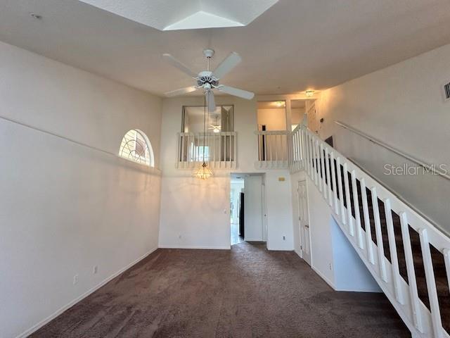 3352 Hamlet Loop, Winter Park, FL 32792 - unfurnished living room with carpet, ceiling fan, and a high ceiling