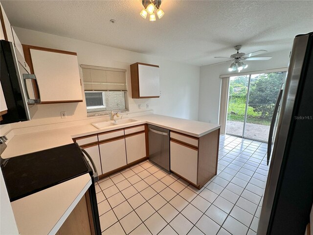 3352 Hamlet Loop, Winter Park, FL 32792 - kitchen with appliances with stainless steel finishes, a peninsula, a textured ceiling, light countertops, and light tile patterned floors