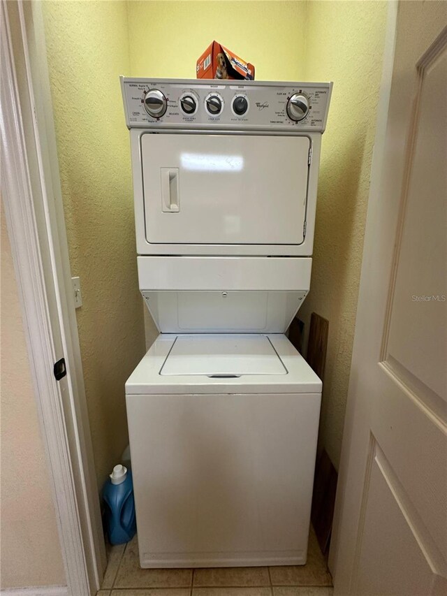 1370 Tuscan Ter Unit 2202, Davenport, FL 33896 - laundry room featuring estacked washer and dryer, light tile patterned floors, and a textured wall