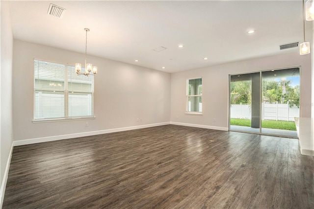 9955 Patrician Dr, New Port Richey, FL 34655 - spare room featuring plenty of natural light, a chandelier, dark wood-style flooring, and recessed lighting