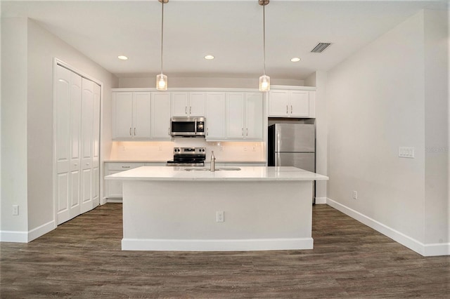 9955 Patrician Dr, New Port Richey, FL 34655 - kitchen featuring stainless steel appliances, dark wood-style flooring, a kitchen island with sink, recessed lighting, and tasteful backsplash