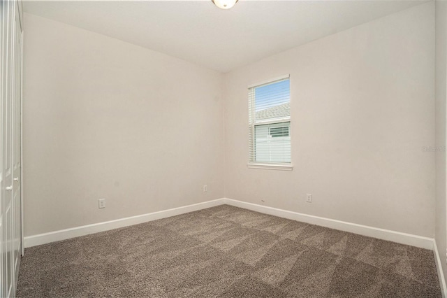 9955 Patrician Dr, New Port Richey, FL 34655 - spare room with baseboards and dark colored carpet