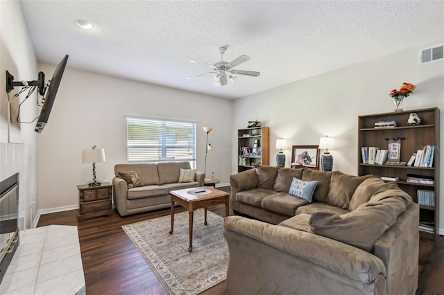 1936 Westpointe Cir, Orlando, FL 32835 - living area with ceiling fan, dark wood-type flooring, a textured ceiling, and a tile fireplace