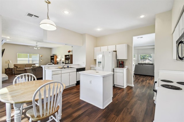 1936 Westpointe Cir, Orlando, FL 32835 - kitchen with a kitchen island, white appliances, open floor plan, dark wood finished floors, and white cabinets