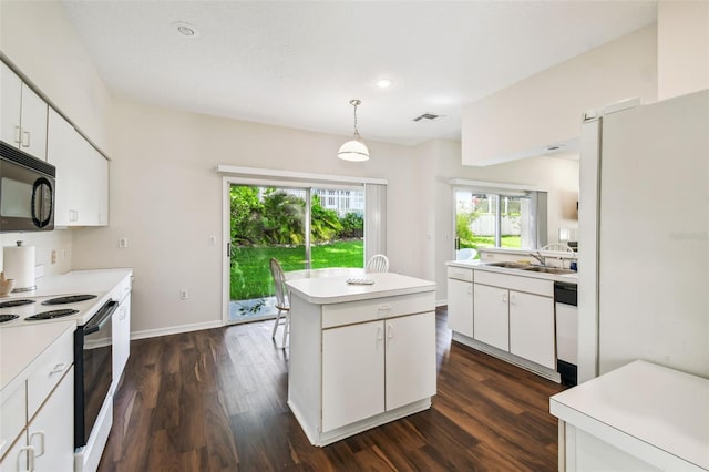 1936 Westpointe Cir, Orlando, FL 32835 - kitchen featuring range with electric stovetop, black microwave, dark wood finished floors, light countertops, and a kitchen island