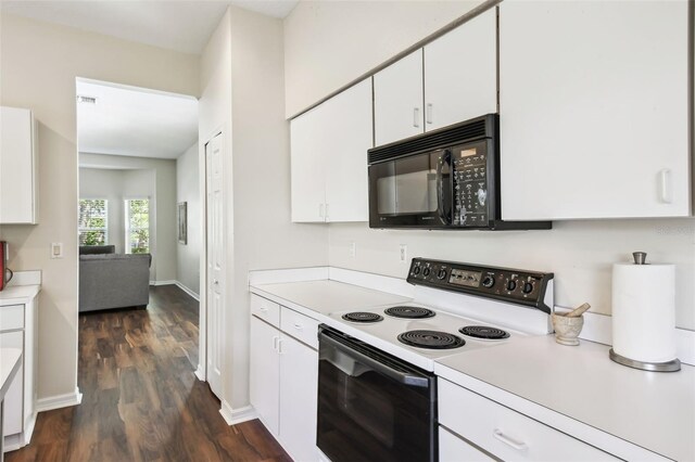 1936 Westpointe Cir, Orlando, FL 32835 - kitchen with white range with electric stovetop, black microwave, light countertops, white cabinets, and dark wood-type flooring