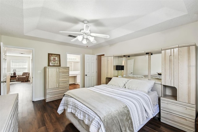 1936 Westpointe Cir, Orlando, FL 32835 - bedroom featuring a tray ceiling, dark wood-style flooring, a ceiling fan, and ensuite bathroom