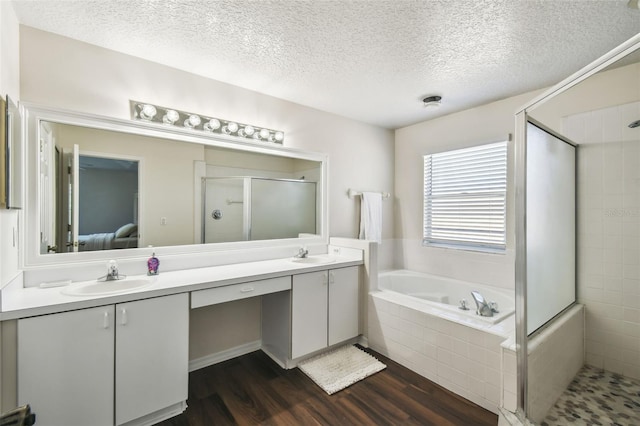 1936 Westpointe Cir, Orlando, FL 32835 - ensuite bathroom with a shower stall, double vanity, wood finished floors, a garden tub, and a textured ceiling