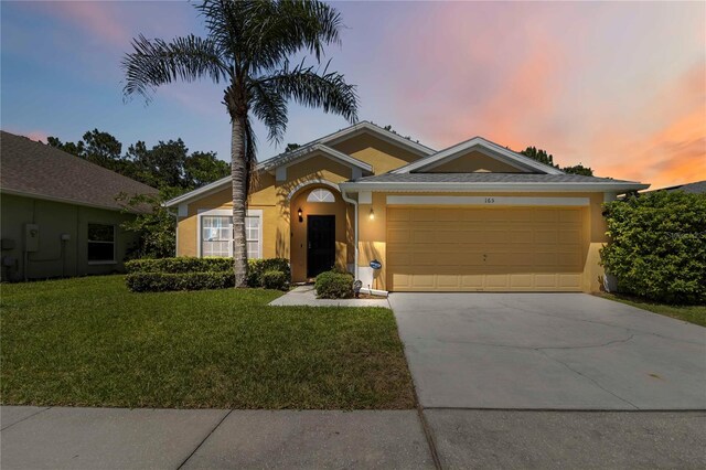 165 Scrub Jay Way, Davenport, FL 33896 - single story home featuring stucco siding, an attached garage, driveway, and a front yard