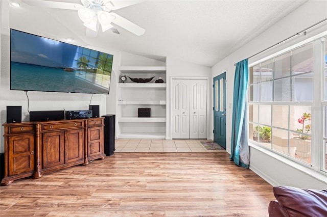 15364 Mount Sparrow Rd, Weeki Wachee, FL 34614 - unfurnished living room featuring lofted ceiling, light wood-style floors, ceiling fan, and built in features