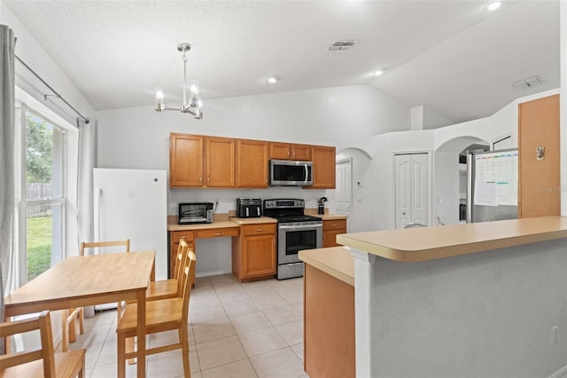 15364 Mount Sparrow Rd, Weeki Wachee, FL 34614 - kitchen with stainless steel appliances, lofted ceiling, arched walkways, light countertops, and light tile patterned floors